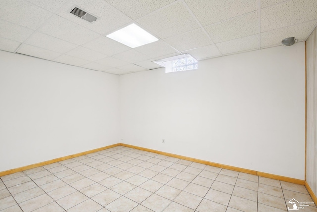 spare room featuring a drop ceiling, visible vents, and baseboards