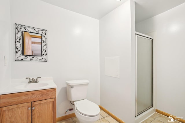 bathroom with a stall shower, vanity, toilet, and tile patterned floors