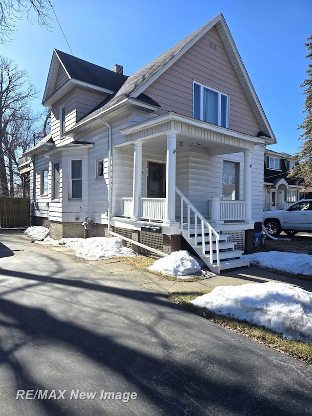 view of front of property with covered porch and a chimney