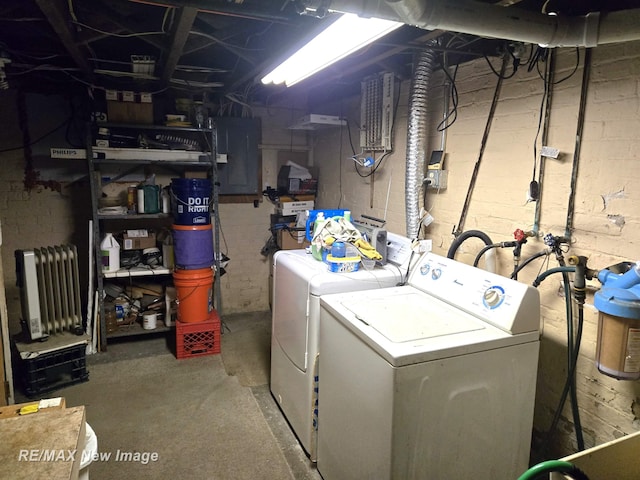 washroom featuring washing machine and dryer, laundry area, electric panel, and radiator