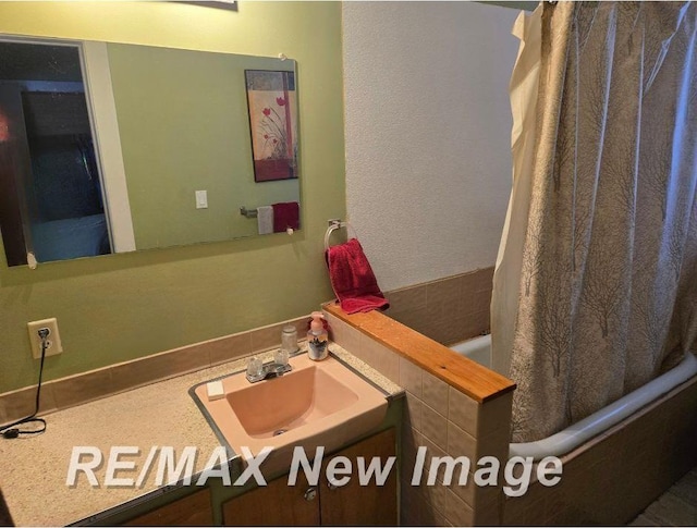 bathroom with shower / tub combo and vanity