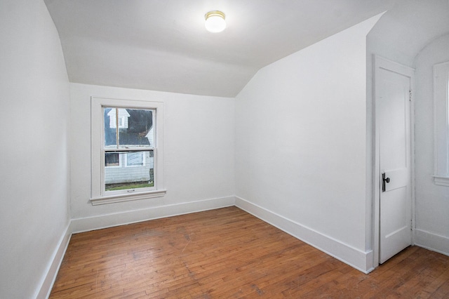 additional living space featuring lofted ceiling, light wood-type flooring, and baseboards