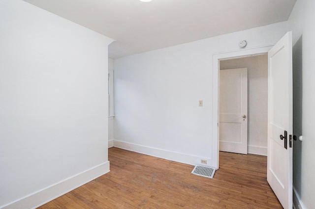 unfurnished room with baseboards, visible vents, and light wood-style floors