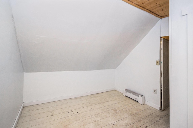 additional living space featuring light wood-style floors, wood ceiling, vaulted ceiling, and baseboards