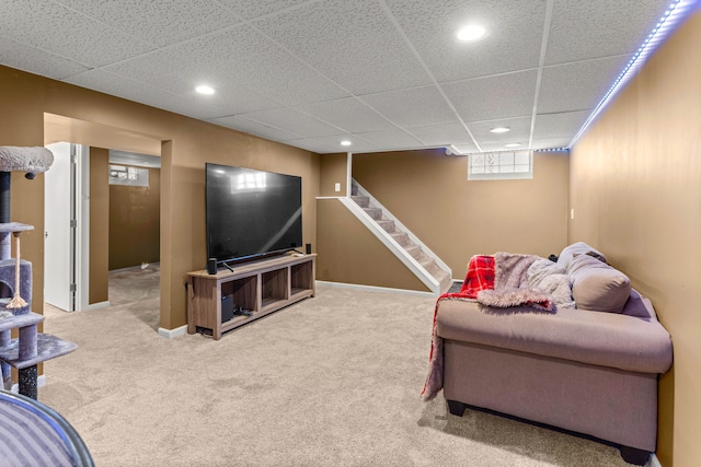 carpeted living area featuring a paneled ceiling, stairs, baseboards, and recessed lighting