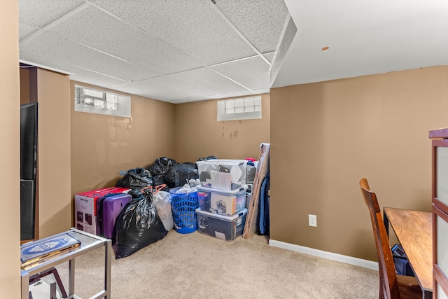 interior space featuring carpet floors, a paneled ceiling, a healthy amount of sunlight, and baseboards