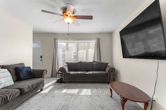 living room with ceiling fan and baseboards