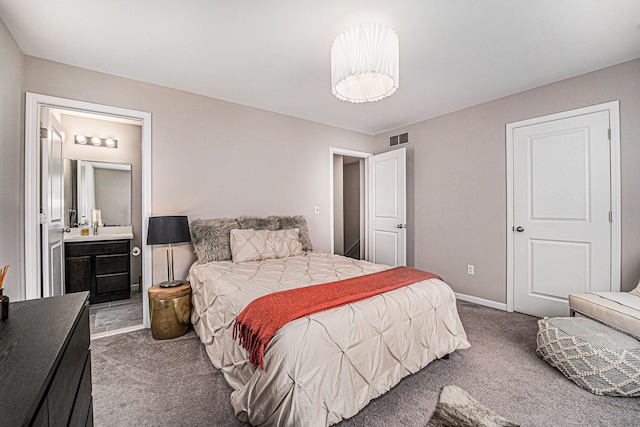 bedroom featuring carpet floors, ensuite bath, baseboards, and visible vents