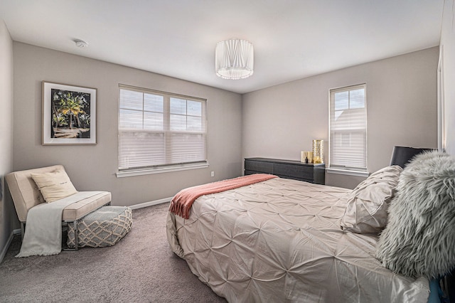 carpeted bedroom featuring multiple windows and baseboards