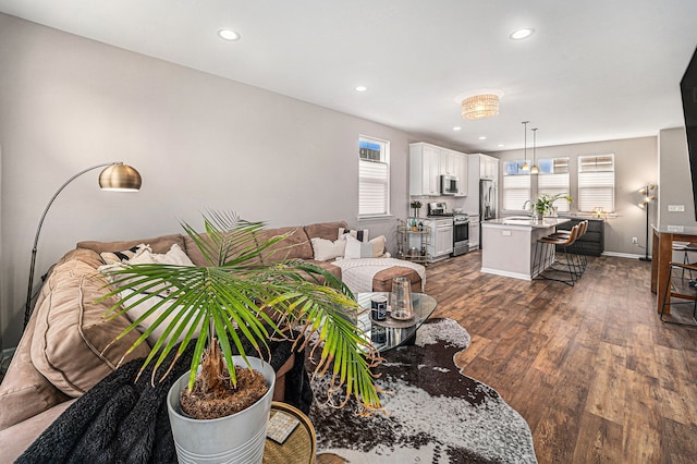 living room featuring baseboards, recessed lighting, dark wood finished floors, and a healthy amount of sunlight