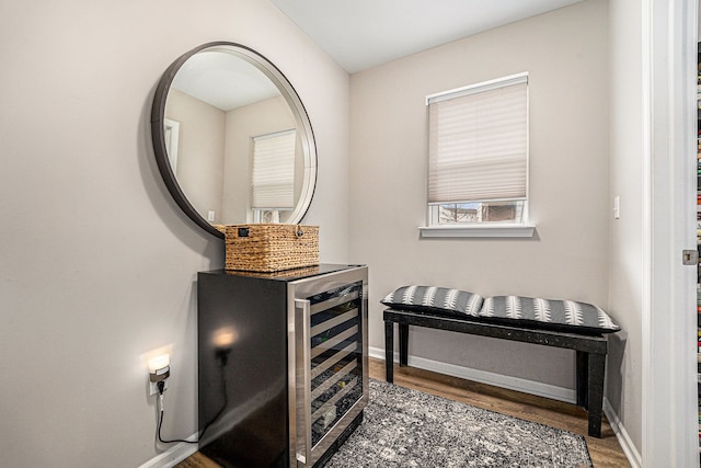 interior space with wine cooler, wood finished floors, and baseboards