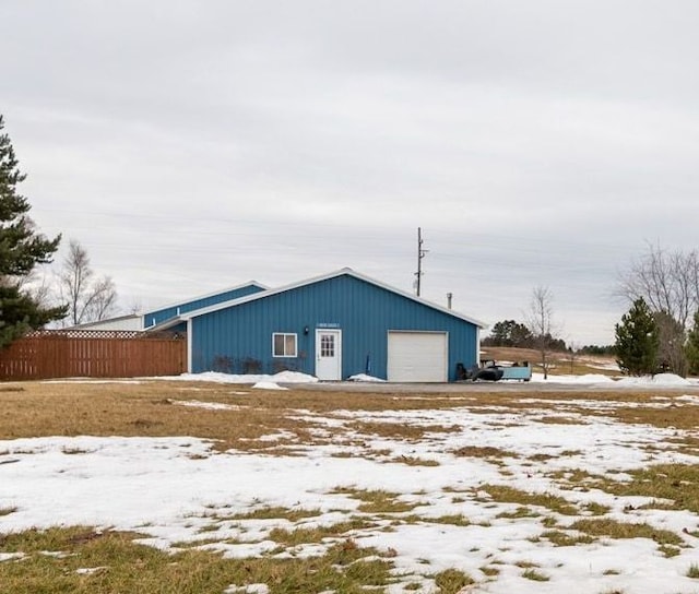 exterior space featuring a detached garage and fence