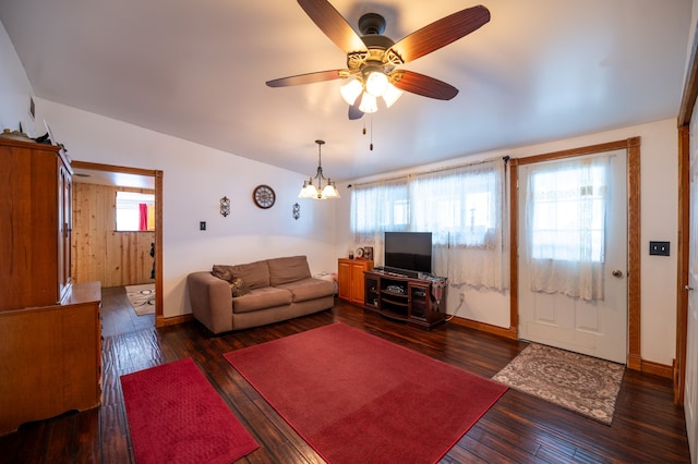 living area with a healthy amount of sunlight, baseboards, hardwood / wood-style floors, and ceiling fan with notable chandelier