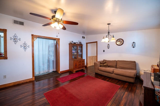 living room featuring wood-type flooring, visible vents, baseboards, and ceiling fan with notable chandelier