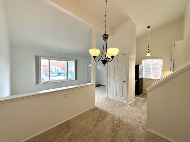 unfurnished dining area with vaulted ceiling, plenty of natural light, carpet flooring, and a chandelier