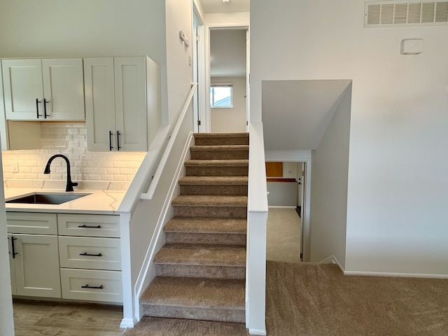 stairs featuring carpet, visible vents, and baseboards