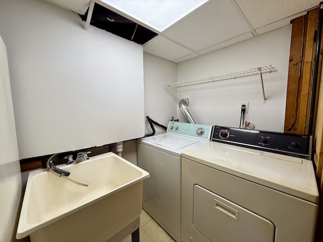 washroom with laundry area, a sink, and washer and dryer