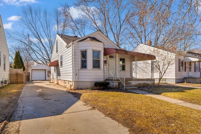 bungalow-style house featuring a garage, an outbuilding, fence, and driveway