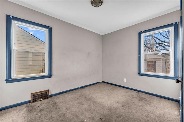 unfurnished room with carpet floors, visible vents, and baseboards