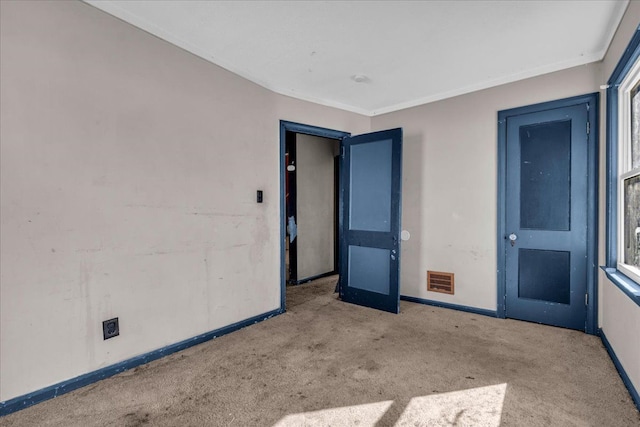 spare room featuring carpet, visible vents, and baseboards