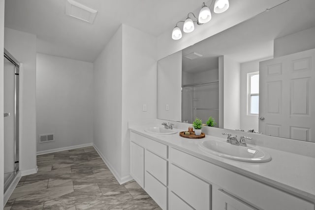 full bath featuring a shower with door, visible vents, double vanity, and a sink