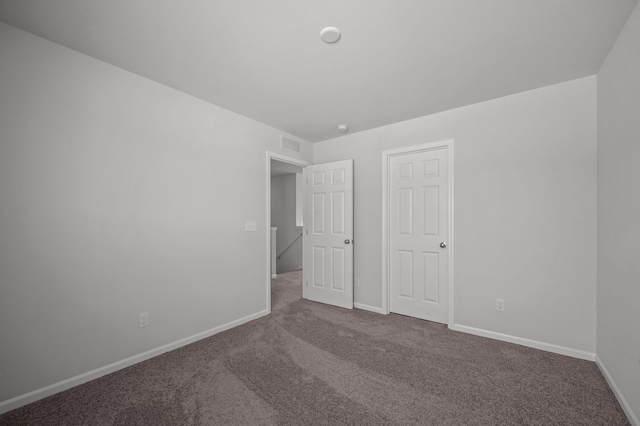 unfurnished bedroom featuring carpet, visible vents, and baseboards