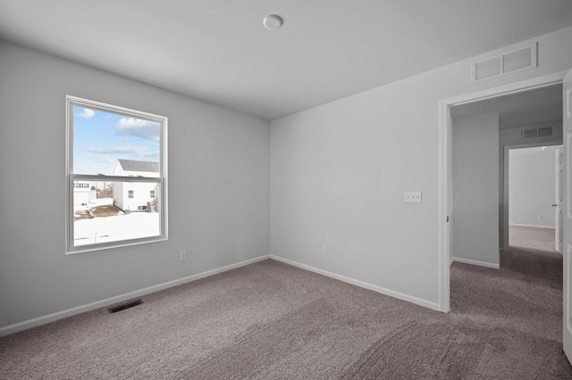 carpeted spare room with visible vents and baseboards