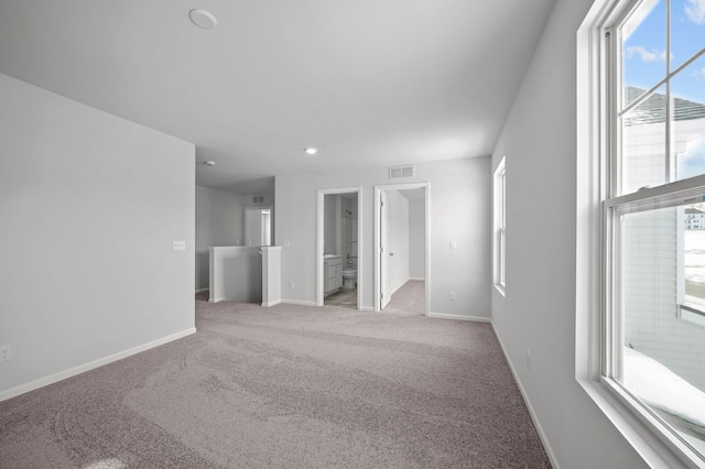 spare room with visible vents, light colored carpet, and baseboards