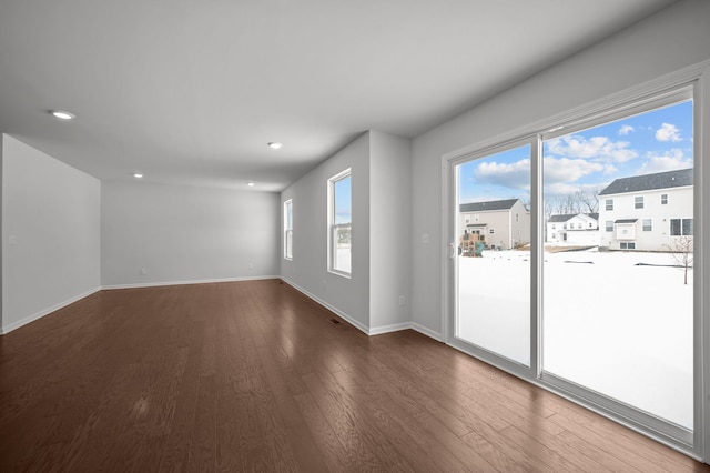 spare room featuring recessed lighting, baseboards, and wood finished floors