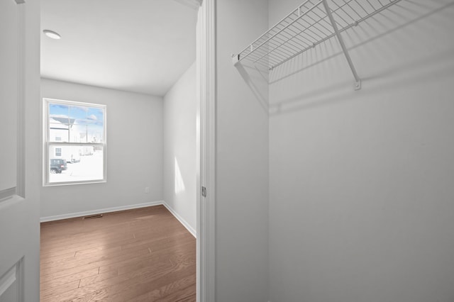 spacious closet with wood finished floors and visible vents