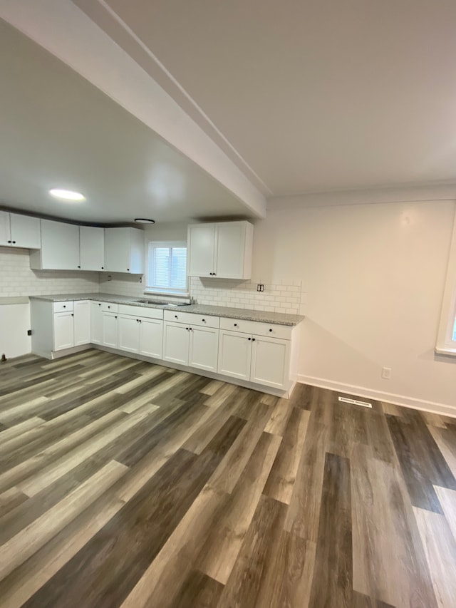 kitchen featuring decorative backsplash, white cabinets, baseboards, and dark wood-style flooring