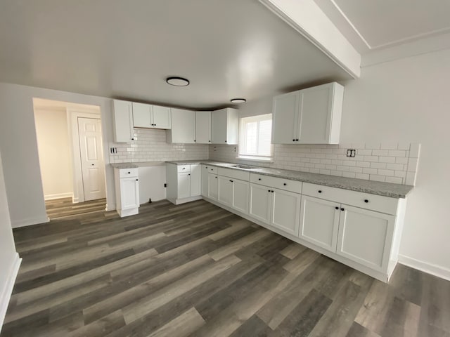 kitchen with white cabinets, dark wood-style floors, tasteful backsplash, and a sink