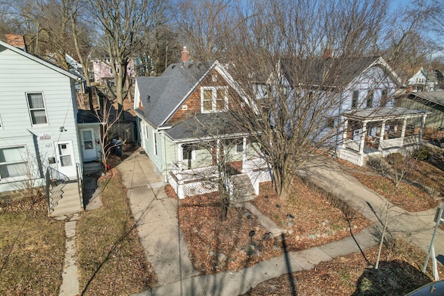 view of front of property featuring a chimney and a shingled roof