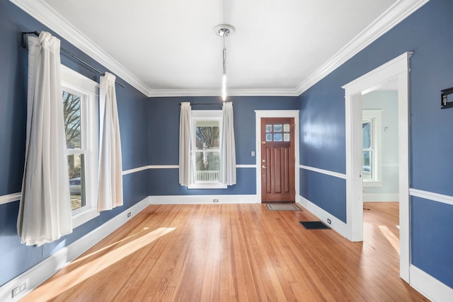 unfurnished dining area featuring hardwood / wood-style flooring, visible vents, baseboards, and ornamental molding