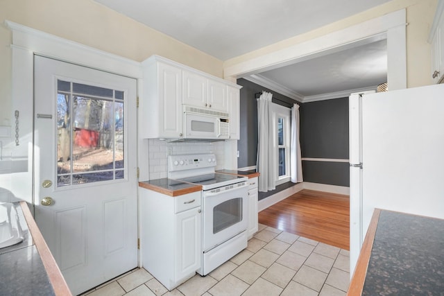 kitchen featuring ornamental molding, backsplash, white appliances, white cabinets, and light tile patterned floors