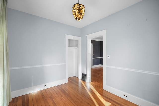 empty room with visible vents, baseboards, and wood finished floors