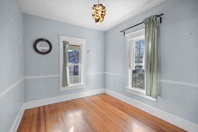 spare room with light wood-type flooring and baseboards