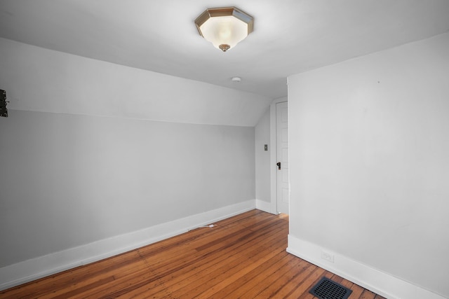 bonus room featuring hardwood / wood-style floors, lofted ceiling, baseboards, and visible vents