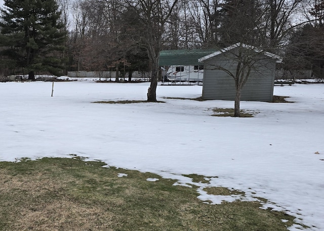 snowy yard featuring a carport