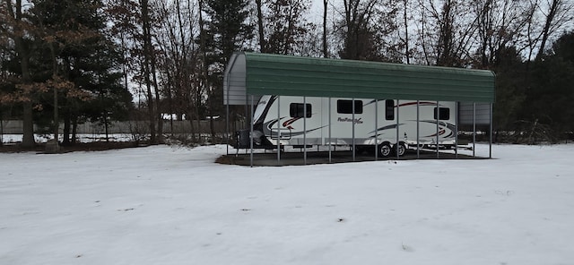 snow covered structure with a detached carport