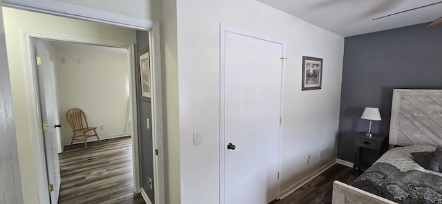 bedroom with dark wood-style floors, ceiling fan, and baseboards