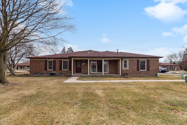 back of house featuring a yard and brick siding