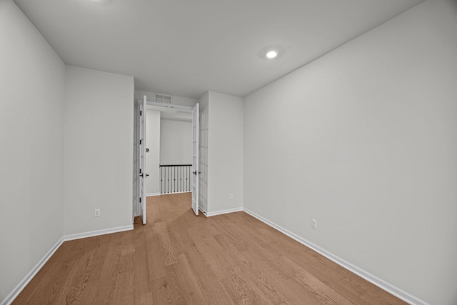 unfurnished room featuring visible vents, baseboards, and wood finished floors