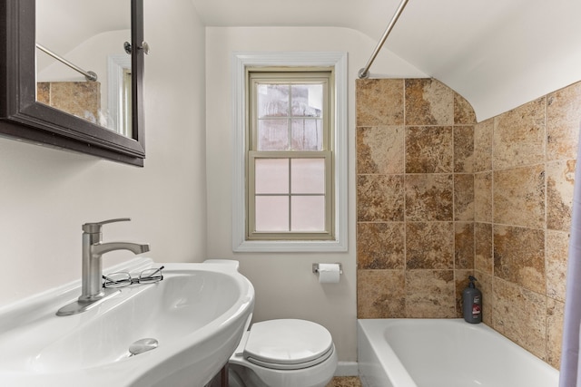 bathroom with lofted ceiling, toilet, a sink, and shower / tub combination