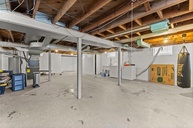 below grade area featuring water heater, washer and clothes dryer, and heating unit