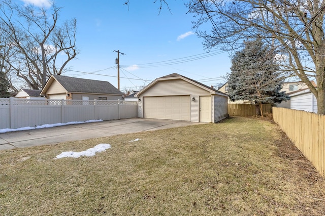 view of yard featuring a detached garage, a fenced backyard, and an outdoor structure