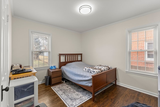 bedroom with crown molding, baseboards, and wood finished floors