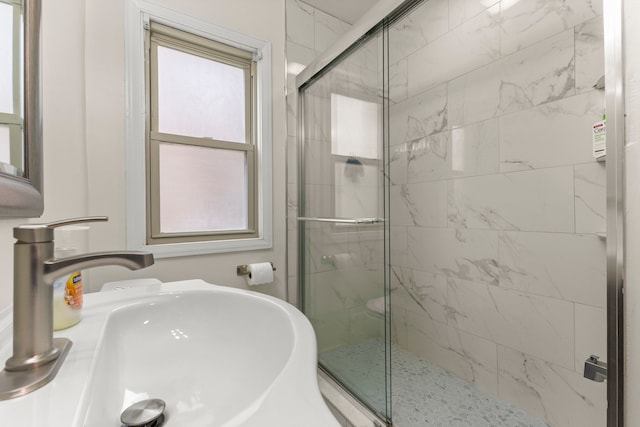 full bath with a wealth of natural light, a sink, and a shower stall