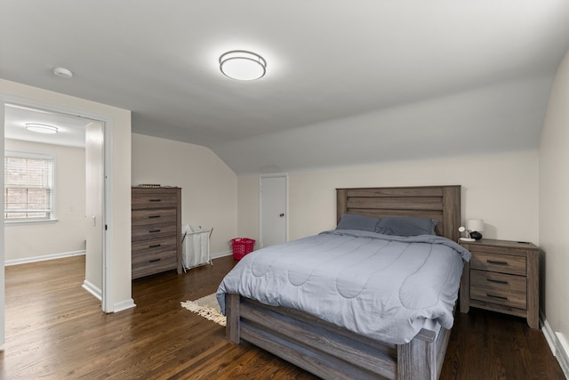 bedroom featuring lofted ceiling, baseboards, and wood finished floors