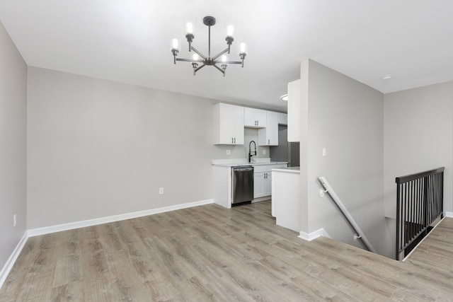 kitchen featuring light wood-style floors, baseboards, light countertops, and dishwashing machine